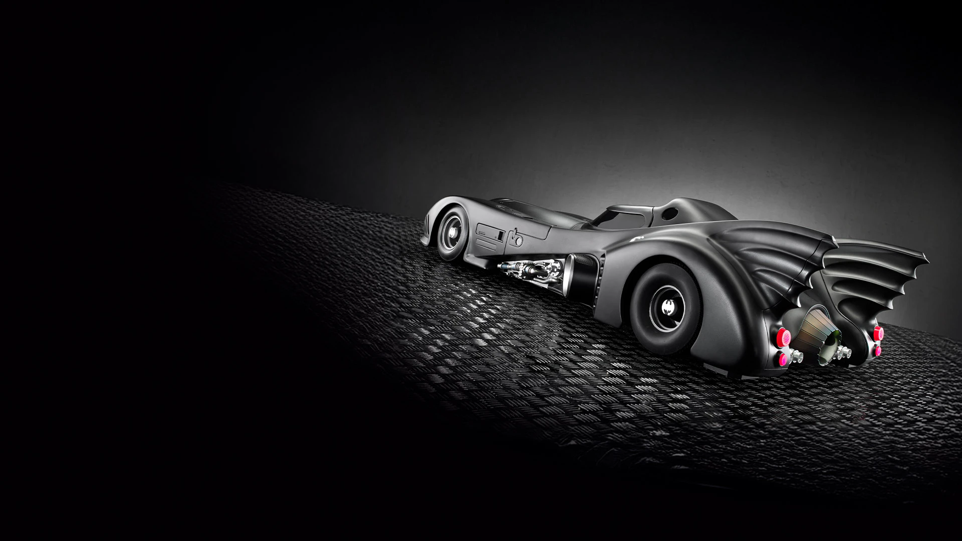 Obraz Batmobilu z 1989 roku na betonie z ciemnym tłem.