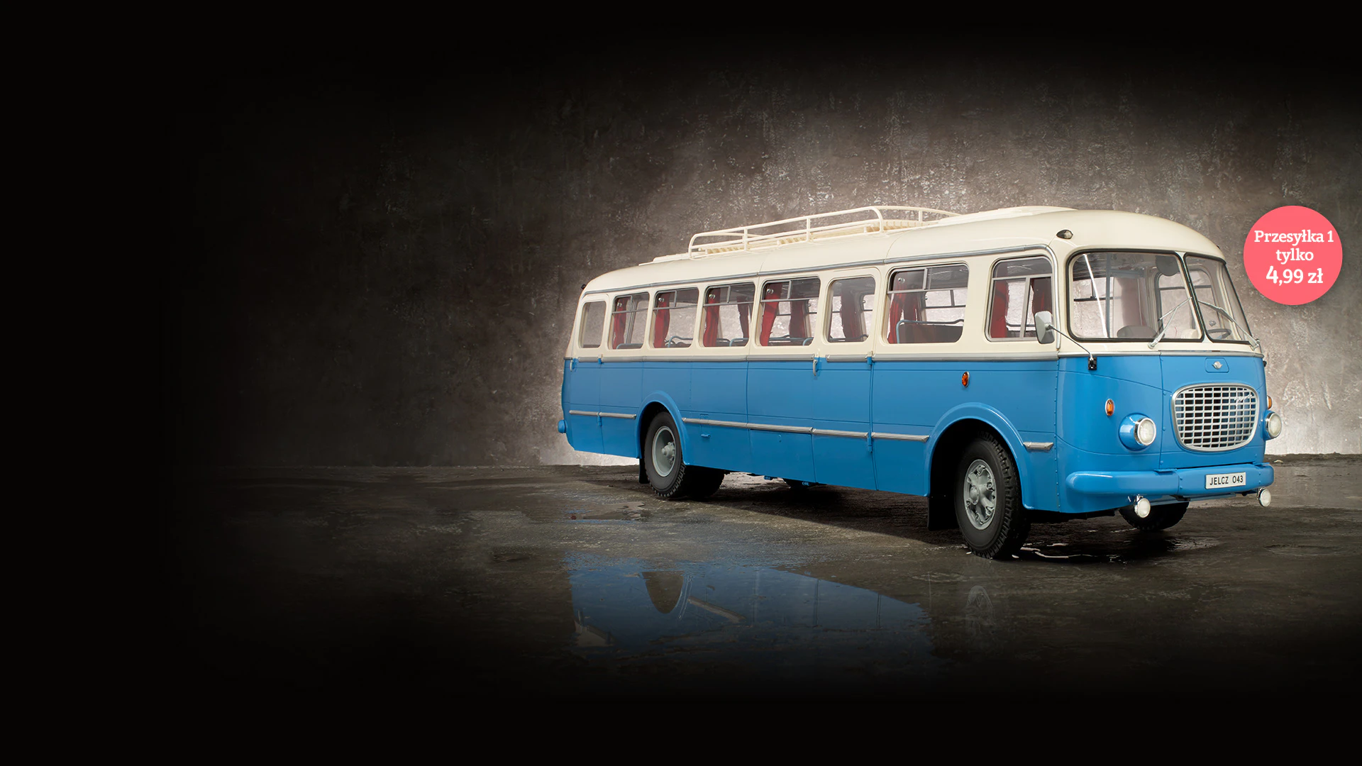 Obraz niebiesko-białego zabytkowego autobusu Jelcz 043 na betonowym tle. Obraz zawiera tekst promocyjny: „Przesyłka 1 tylko 4,99 zł”.